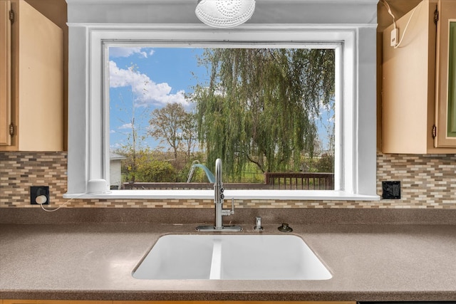 kitchen featuring decorative backsplash, a healthy amount of sunlight, and sink