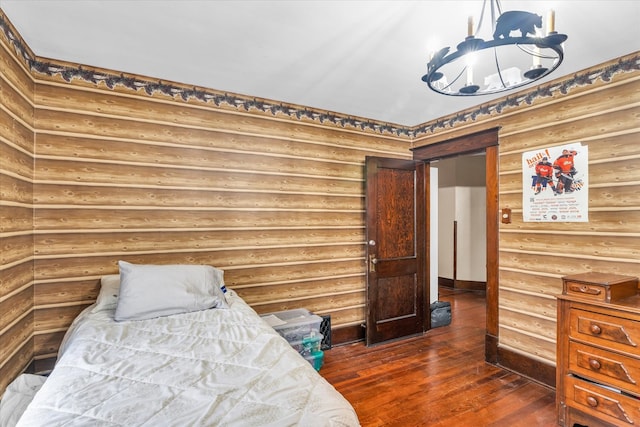 bedroom featuring log walls and dark hardwood / wood-style flooring