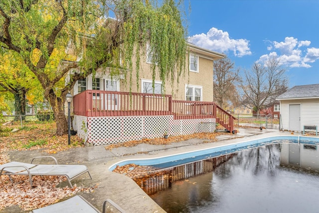 rear view of property with a pool side deck