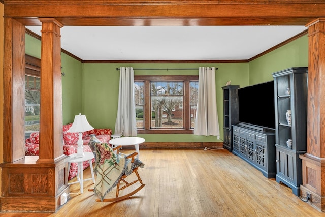 sitting room featuring decorative columns, hardwood / wood-style floors, and ornamental molding