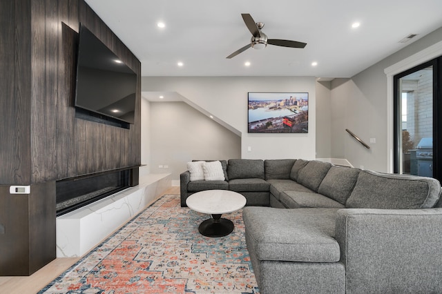 living room with ceiling fan and light hardwood / wood-style flooring