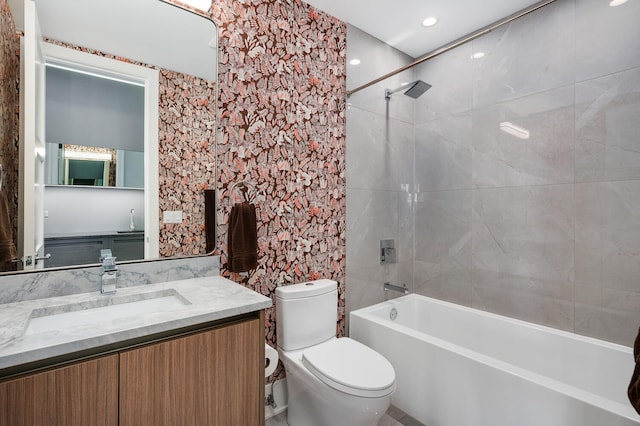 full bathroom featuring vanity, tiled shower / bath combo, and toilet