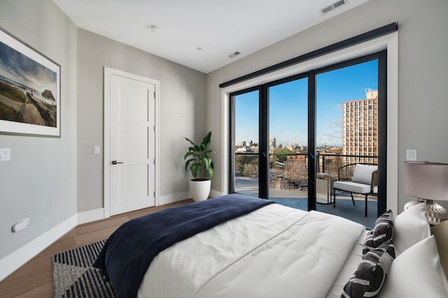 bedroom featuring access to outside and hardwood / wood-style flooring