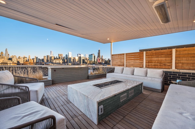 wooden terrace featuring an outdoor living space with a fire pit