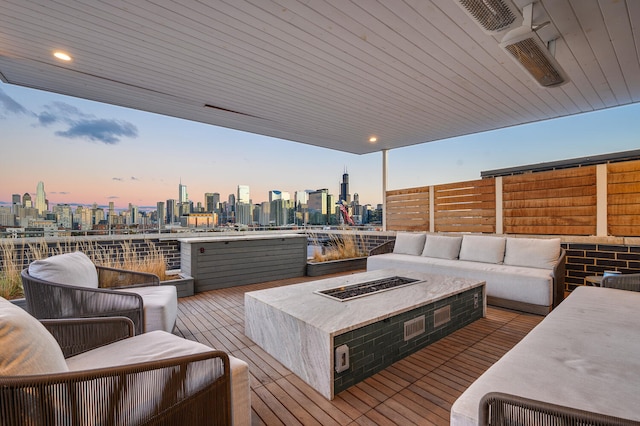 deck at dusk featuring an outdoor living space with a fire pit