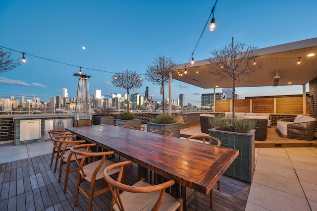 deck at dusk with exterior bar and an outdoor living space