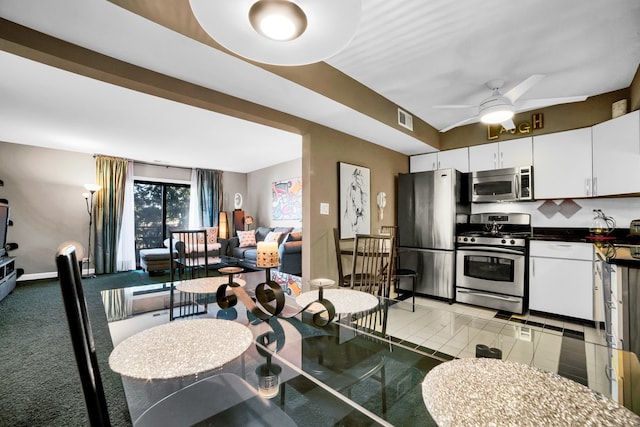 kitchen featuring appliances with stainless steel finishes, backsplash, ceiling fan, light tile patterned floors, and white cabinets