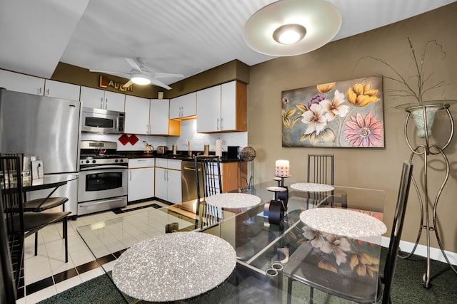 kitchen featuring backsplash, white cabinets, sink, ceiling fan, and stainless steel appliances