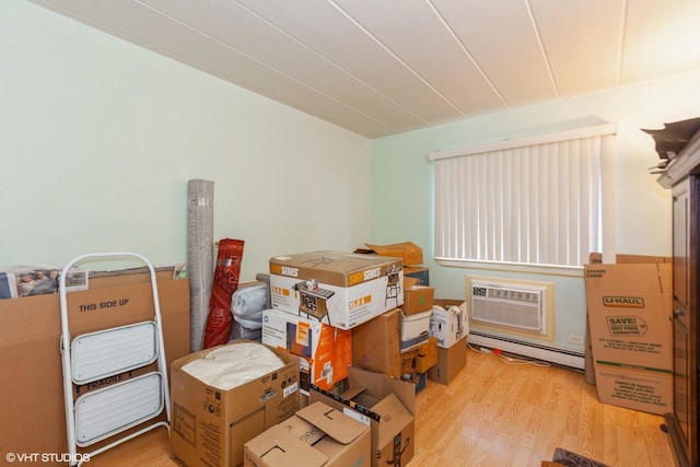 storage room featuring an AC wall unit and a baseboard radiator