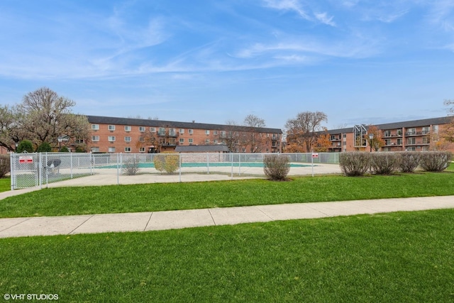 view of home's community with a pool, a yard, and fence