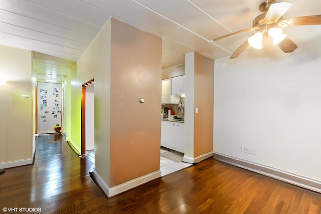 interior space with ceiling fan, hardwood / wood-style floors, and baseboards