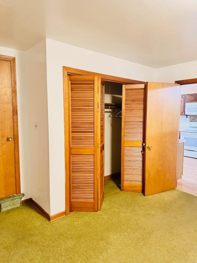 unfurnished bedroom featuring light carpet and a closet