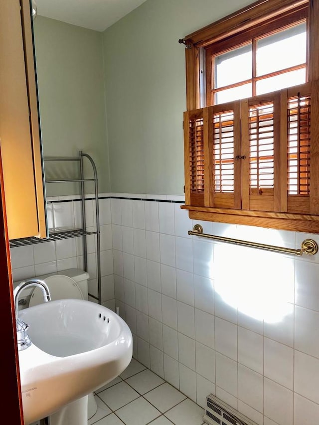 bathroom with tile patterned floors, sink, and tile walls