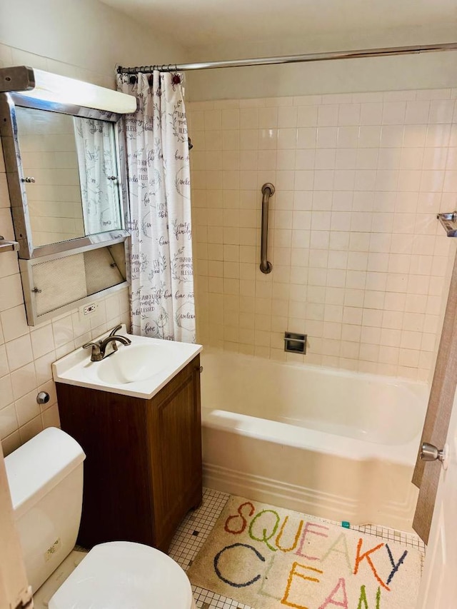 full bathroom with tile patterned floors, tile walls, toilet, vanity, and shower / tub combo