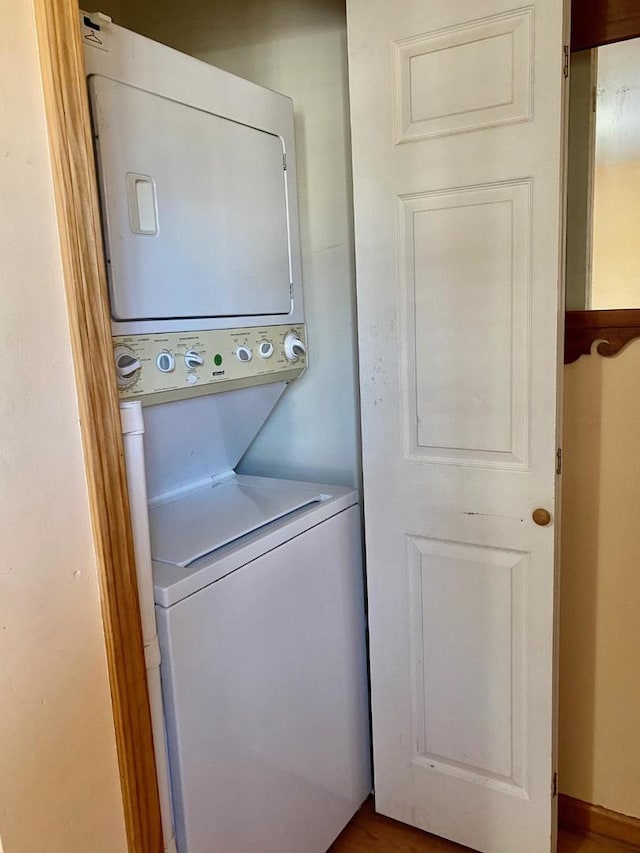 clothes washing area featuring stacked washer and clothes dryer