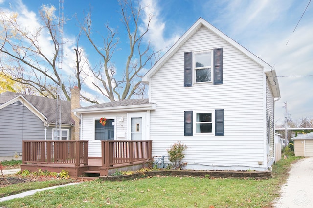 rear view of house featuring a wooden deck and a yard