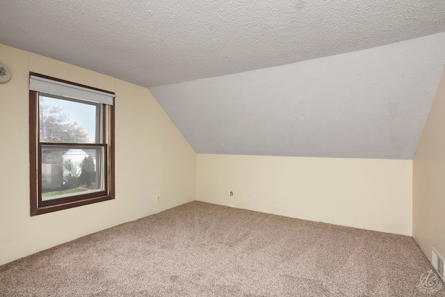 bonus room with carpet flooring, a textured ceiling, and lofted ceiling