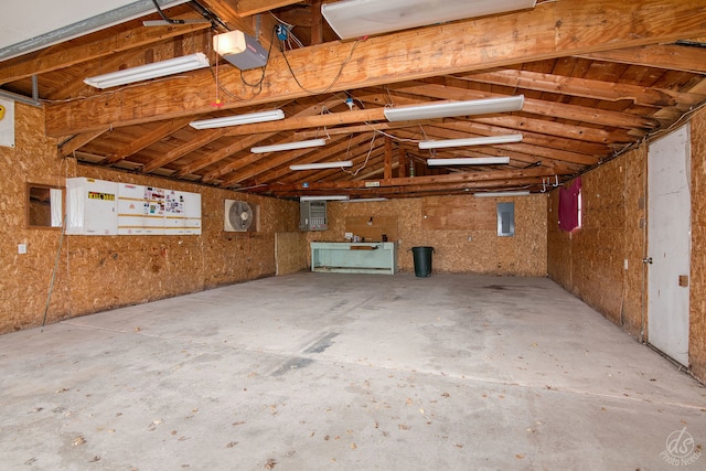 misc room with lofted ceiling and electric panel