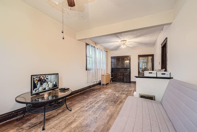 interior space with hardwood / wood-style flooring, a textured ceiling, and beamed ceiling