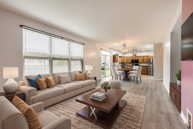 living room featuring an inviting chandelier and light wood-type flooring