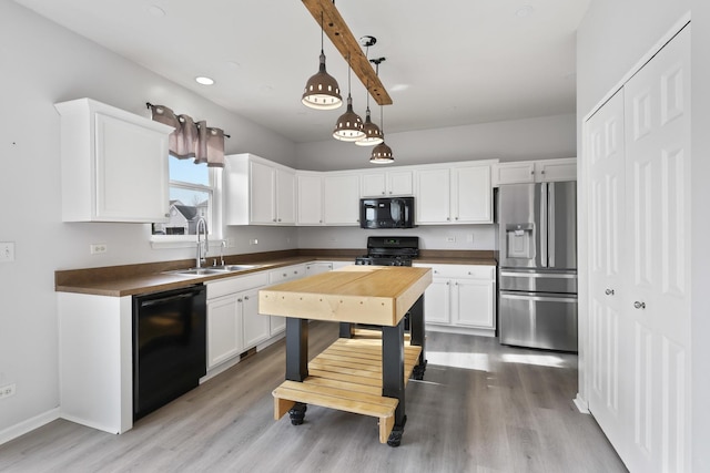 kitchen featuring pendant lighting, sink, black appliances, and white cabinets