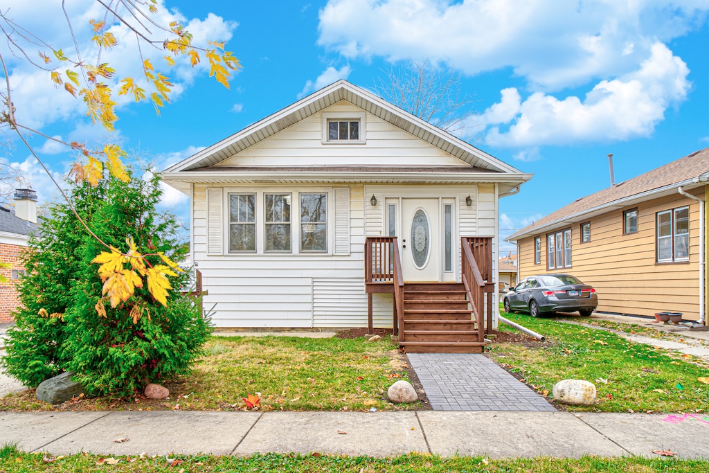 bungalow featuring a front lawn