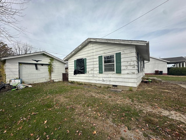 exterior space with a lawn, an outbuilding, cooling unit, and a garage