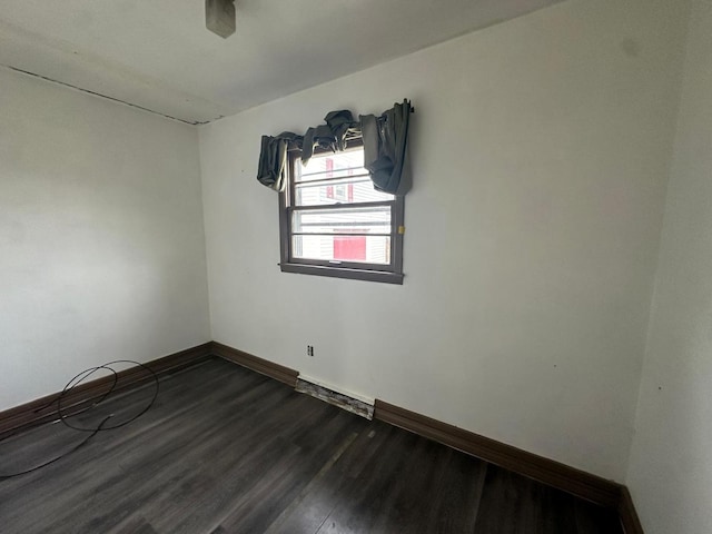 spare room featuring ceiling fan and dark wood-type flooring