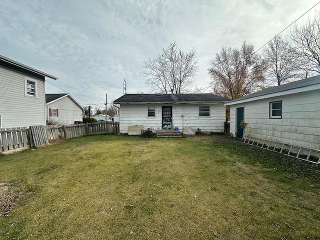 rear view of property featuring a lawn