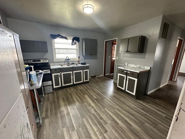 kitchen featuring gray cabinets, sink, dark wood-type flooring, and stainless steel electric range