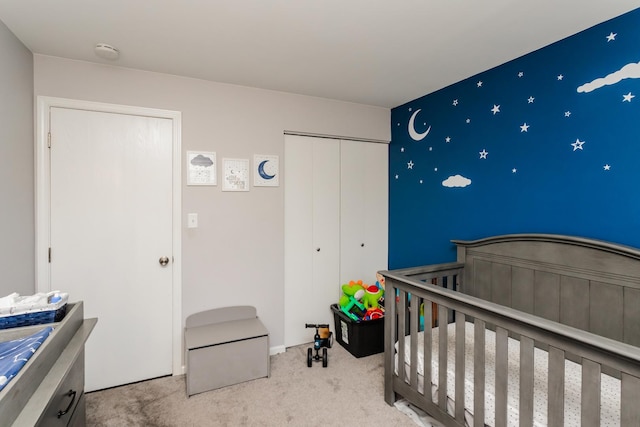 carpeted bedroom featuring a closet and a crib