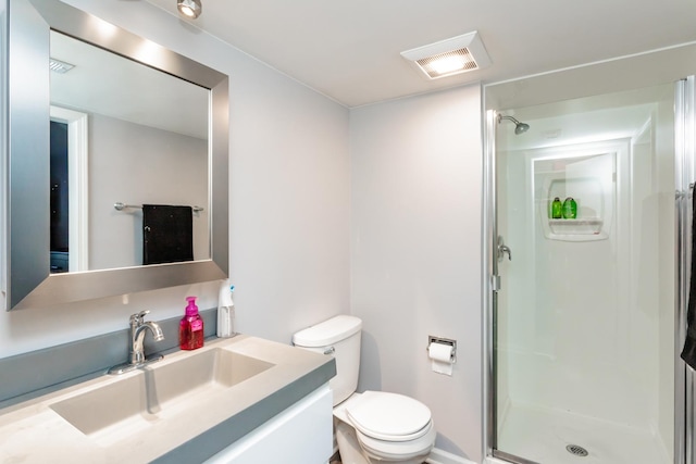 bathroom with vanity, a shower with shower door, and toilet