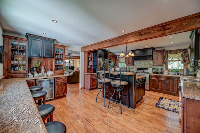 kitchen with a kitchen bar, a center island, stainless steel appliances, and wine cooler