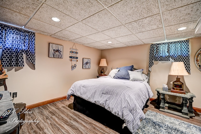 bedroom with hardwood / wood-style flooring and a paneled ceiling