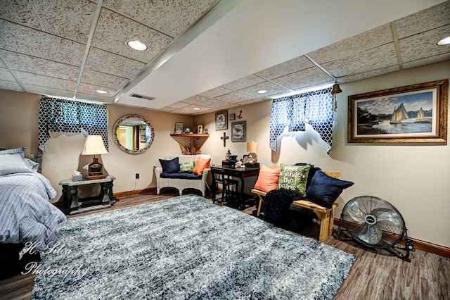 bedroom featuring a drop ceiling and hardwood / wood-style flooring