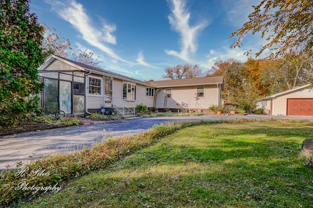 ranch-style house with a garage, an outbuilding, and a front yard