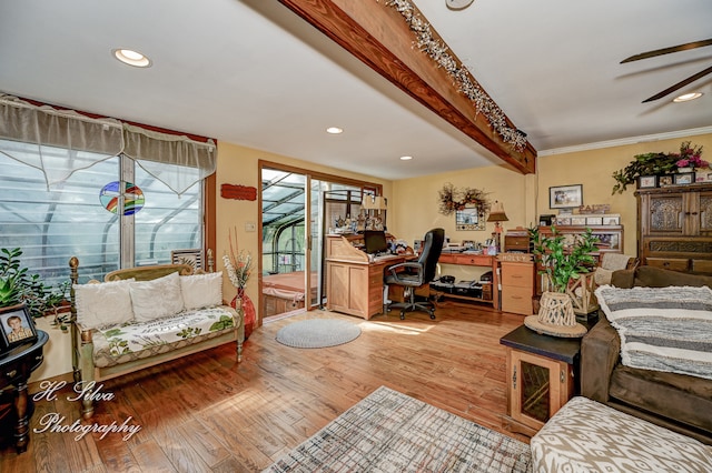 living room featuring crown molding, ceiling fan, built in desk, beamed ceiling, and light hardwood / wood-style floors