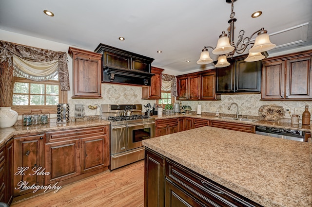 kitchen featuring sink, an inviting chandelier, light hardwood / wood-style floors, decorative light fixtures, and appliances with stainless steel finishes