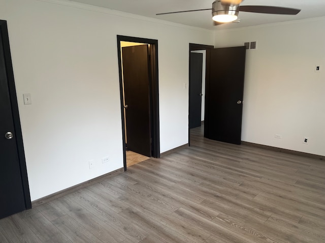 unfurnished bedroom featuring ceiling fan, ornamental molding, and light hardwood / wood-style flooring