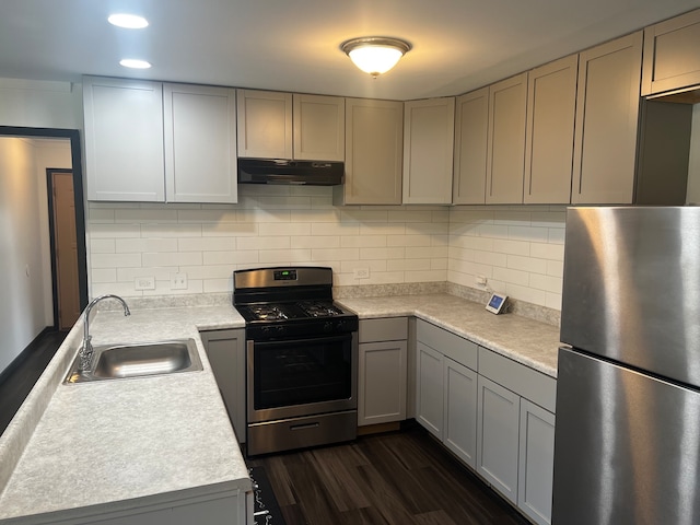 kitchen featuring sink, dark wood-type flooring, backsplash, gray cabinets, and appliances with stainless steel finishes