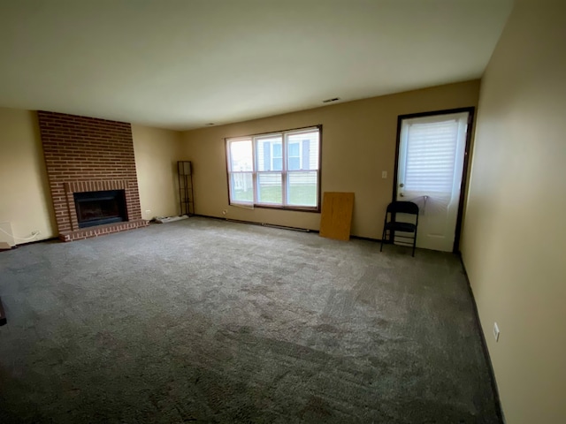 unfurnished living room featuring a fireplace and dark carpet