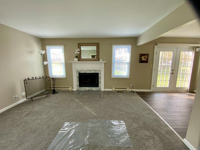 unfurnished living room featuring hardwood / wood-style floors, a baseboard radiator, french doors, and a premium fireplace