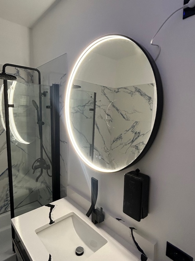 bathroom with a tile shower and vanity