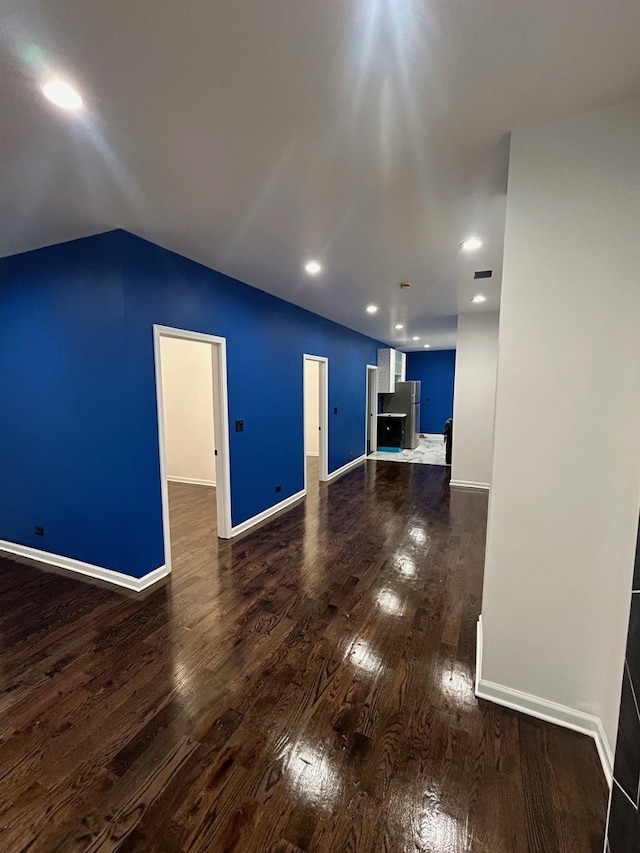 unfurnished living room with hardwood / wood-style floors and vaulted ceiling