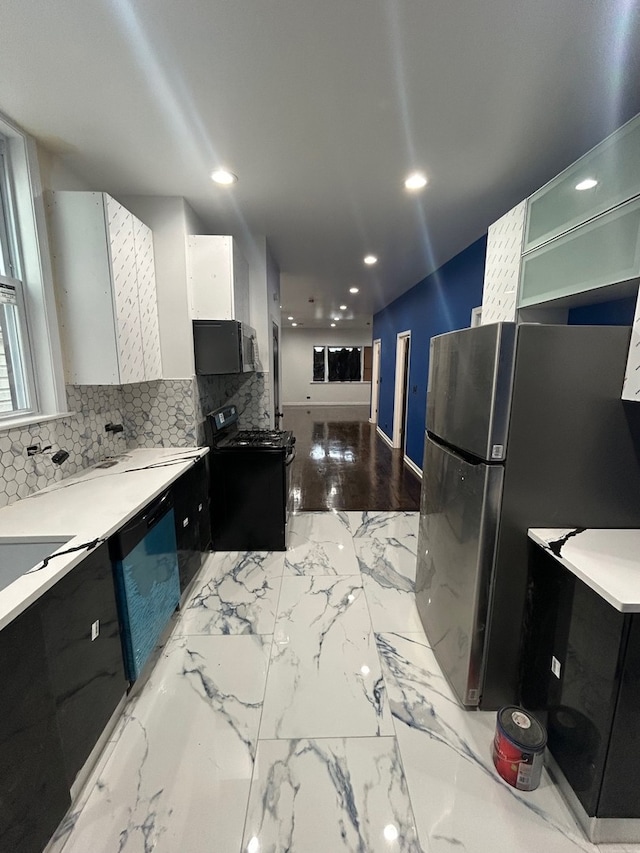 kitchen featuring white cabinetry, decorative backsplash, and black appliances