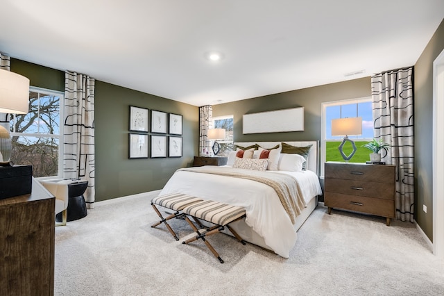 bedroom featuring multiple windows and light carpet