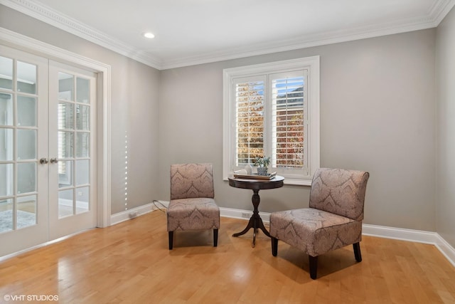 sitting room with crown molding, french doors, and light hardwood / wood-style floors