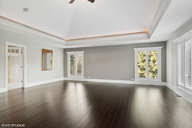 unfurnished room featuring ornamental molding, a raised ceiling, ceiling fan, and dark wood-type flooring