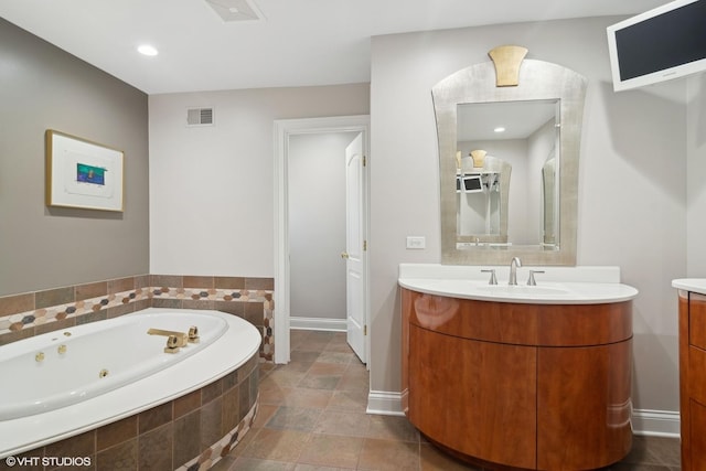 bathroom with tiled bath and vanity