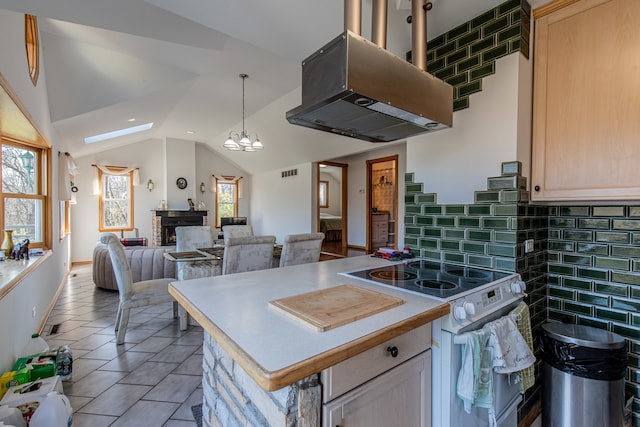 kitchen featuring a wealth of natural light, island range hood, and light brown cabinetry